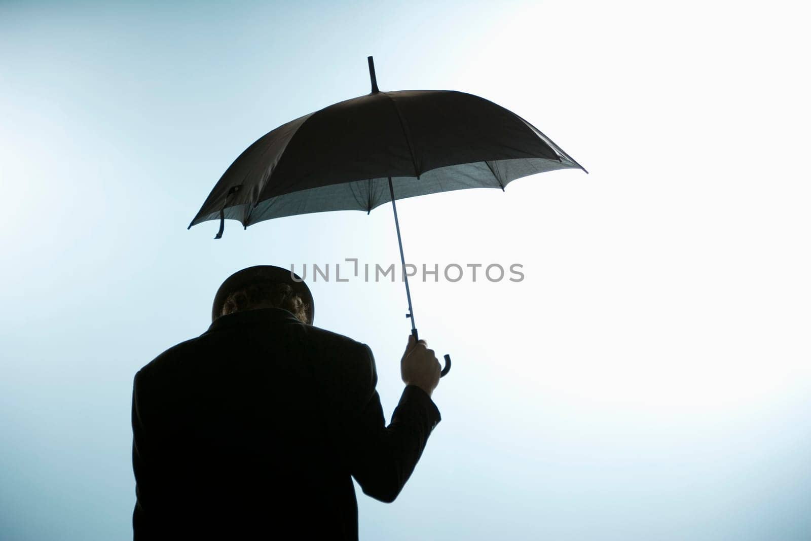 Person with head down holding umbrella