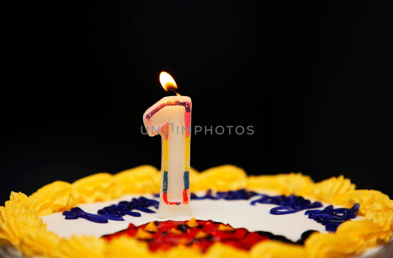 A birthday cake with lit candle