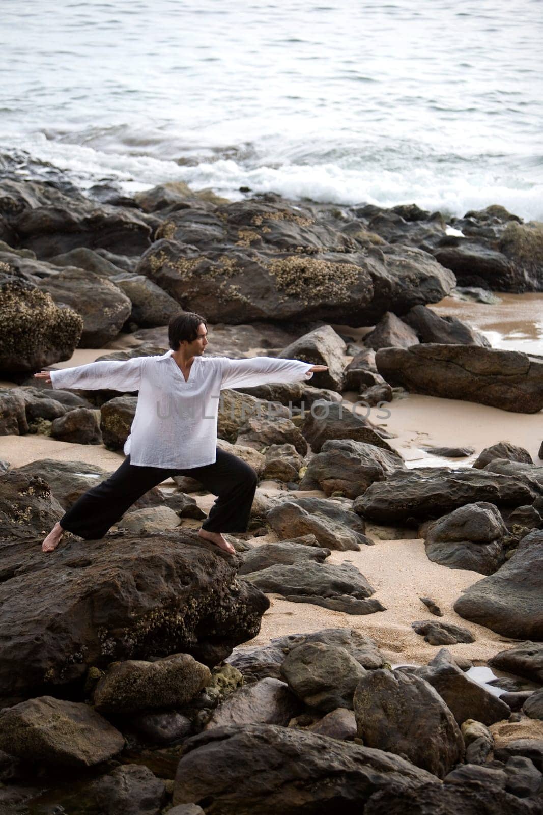 A man stretching on a rocky beach in Koh Lanta,Thailand