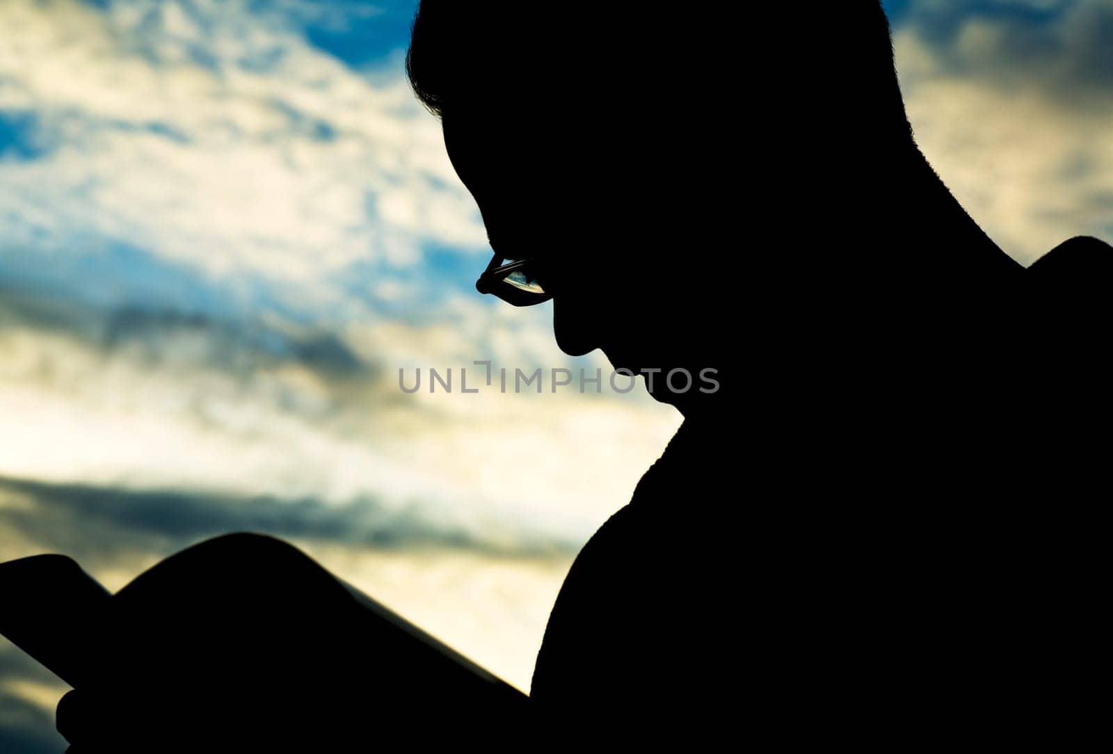 Silhouette of man reading