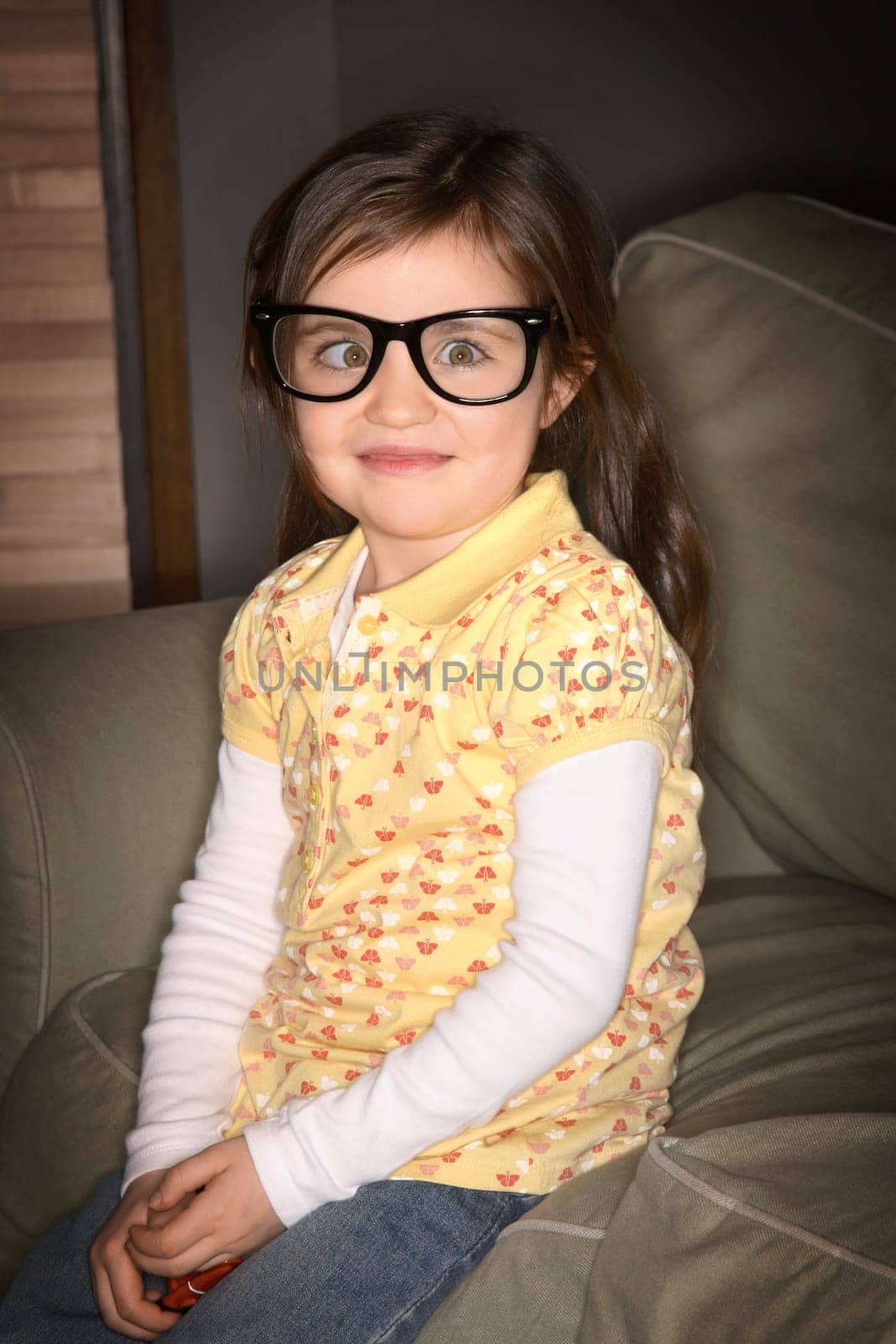 A girl wearing glasses, crossing her eyes