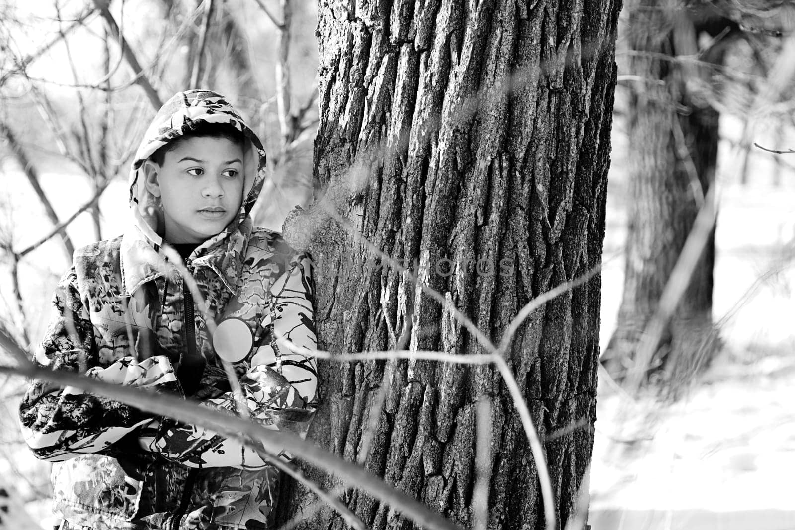 Teenage Boy Hunting In A Snow Covered Wooded Area