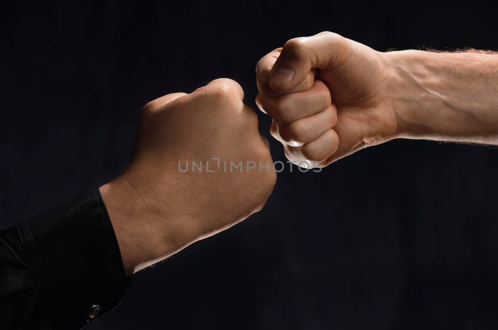 Two men knocking fists together