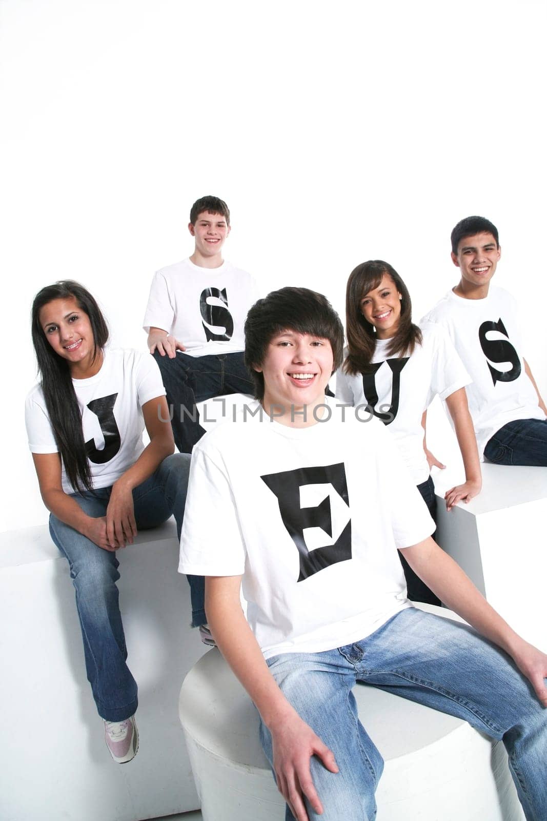 Five teenagers with t-shirts spelling Jesus