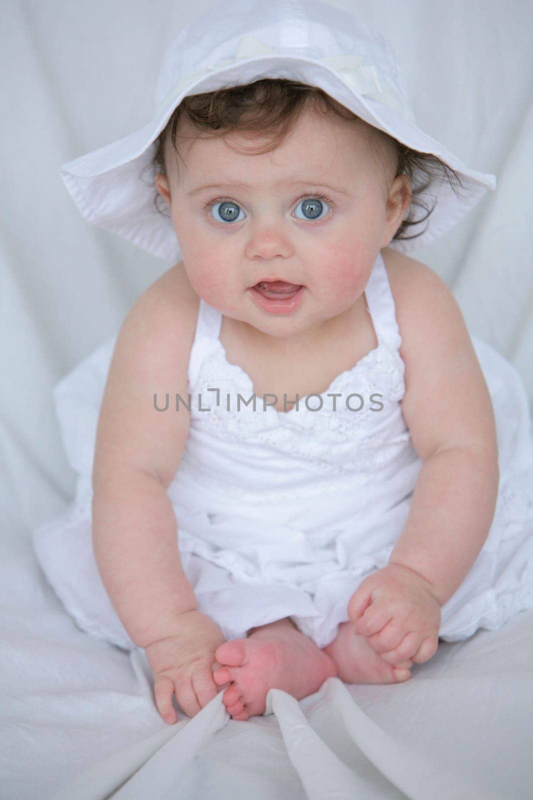 Baby girl in white dress and hat