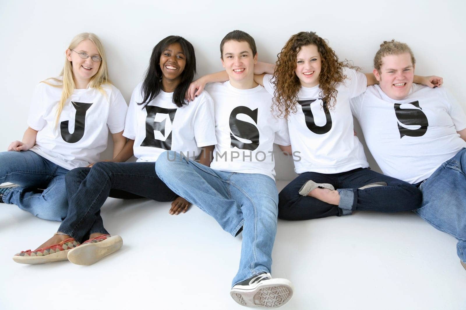 Five teenagers with t-shirts spelling Jesus