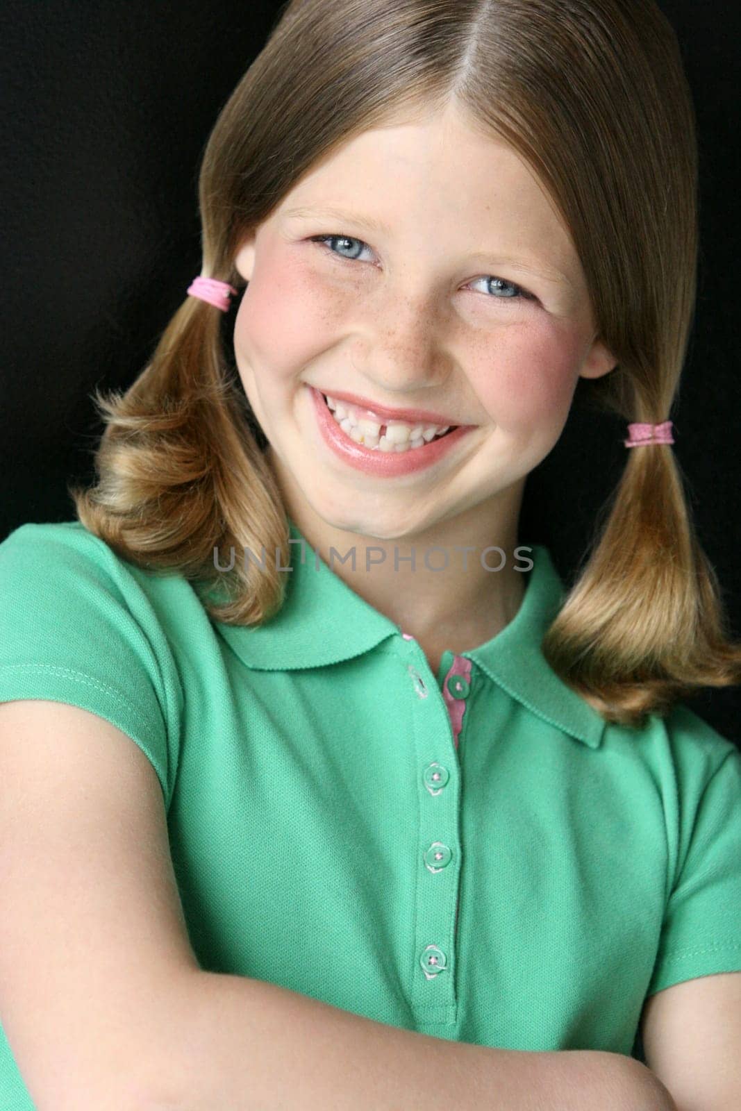 Young girl with pigtails in green polo shirt