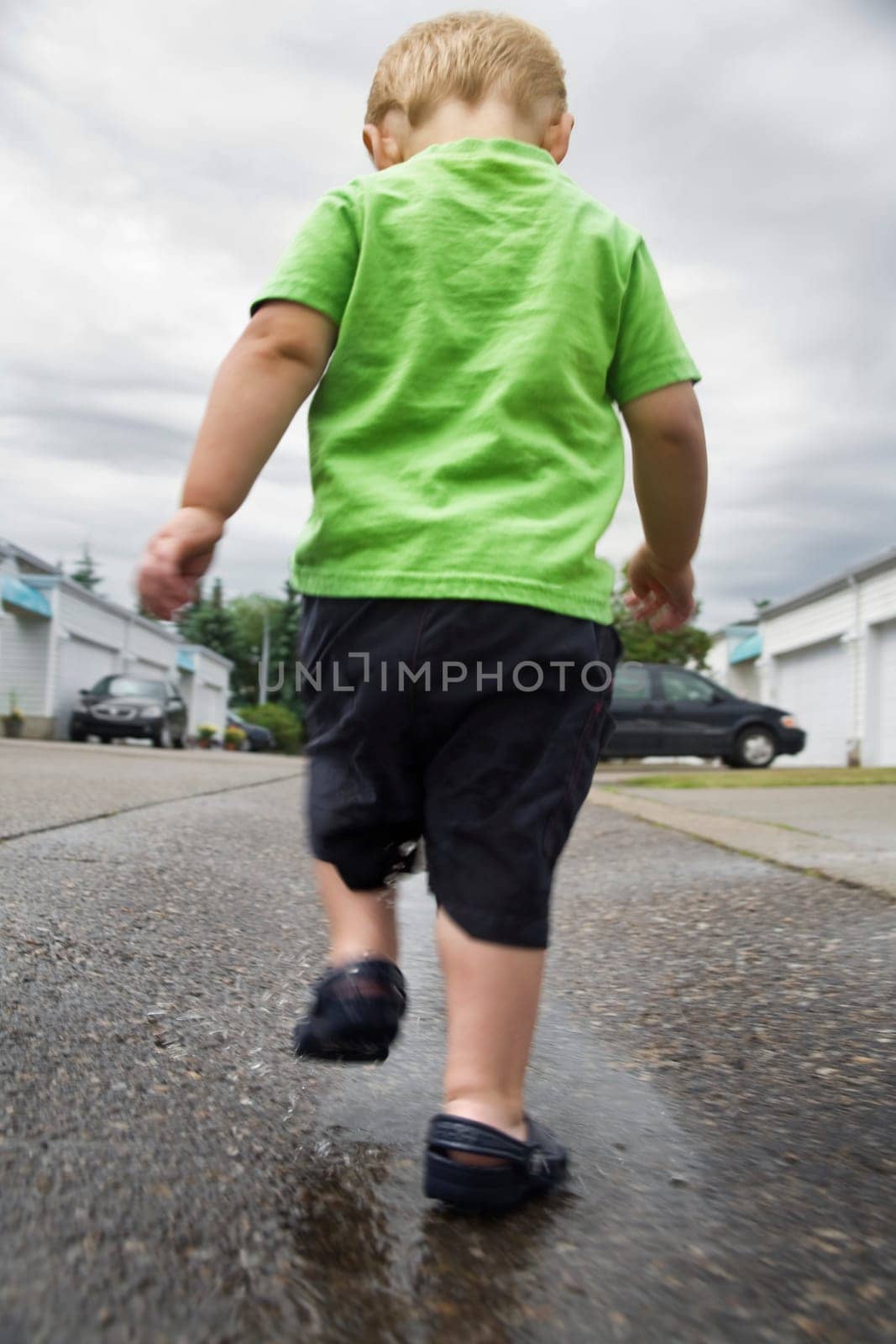 Boy walking in a puddle
