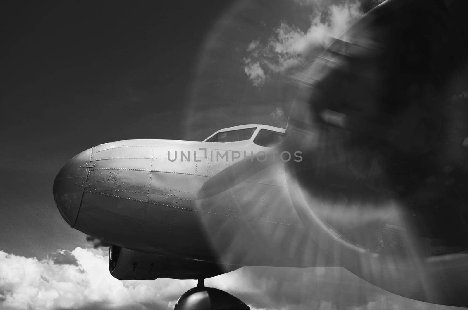 Vintage twin engine airplane with propeller rotating in black and white