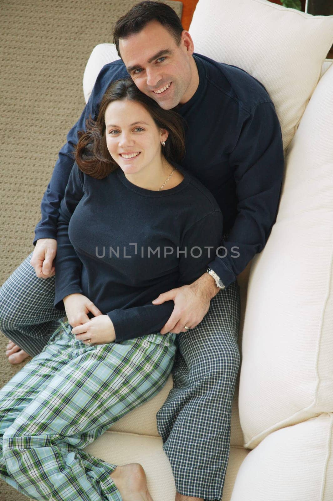 Couple snuggles on sofa