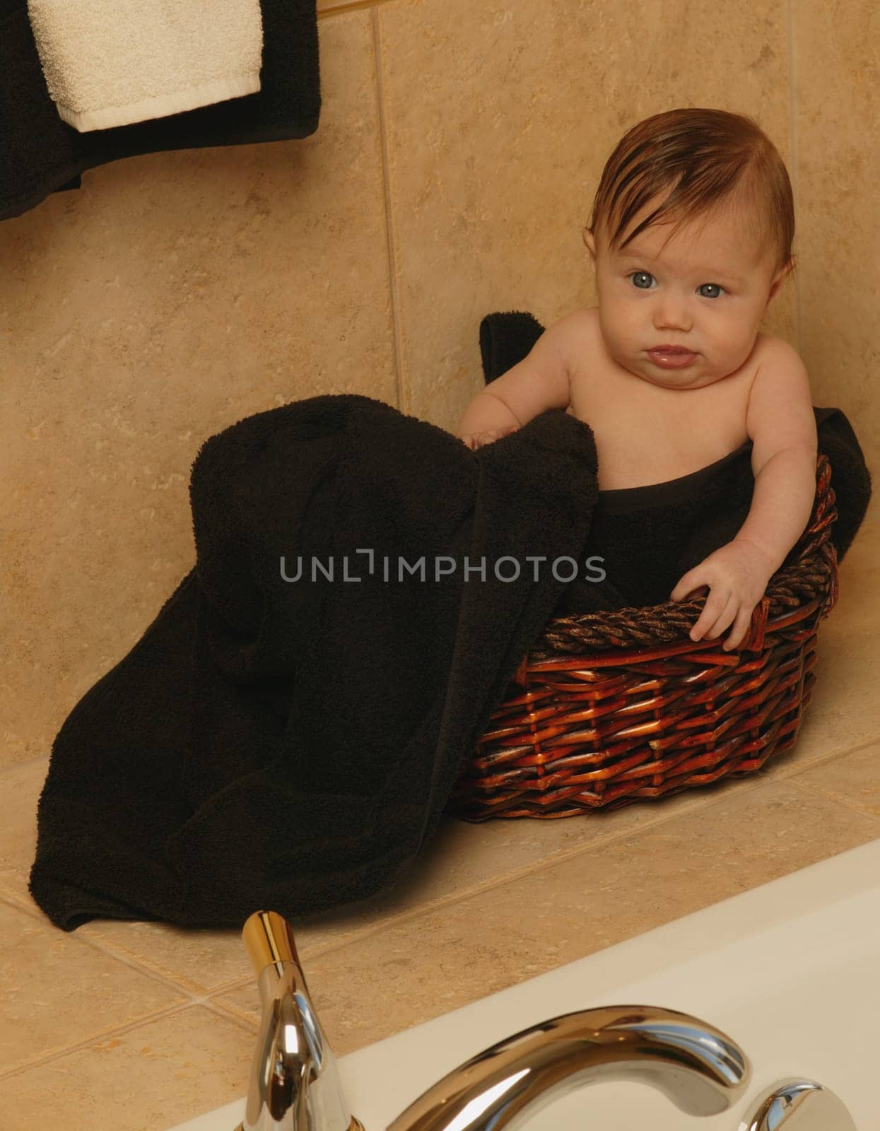 Baby sits in bathroom basket