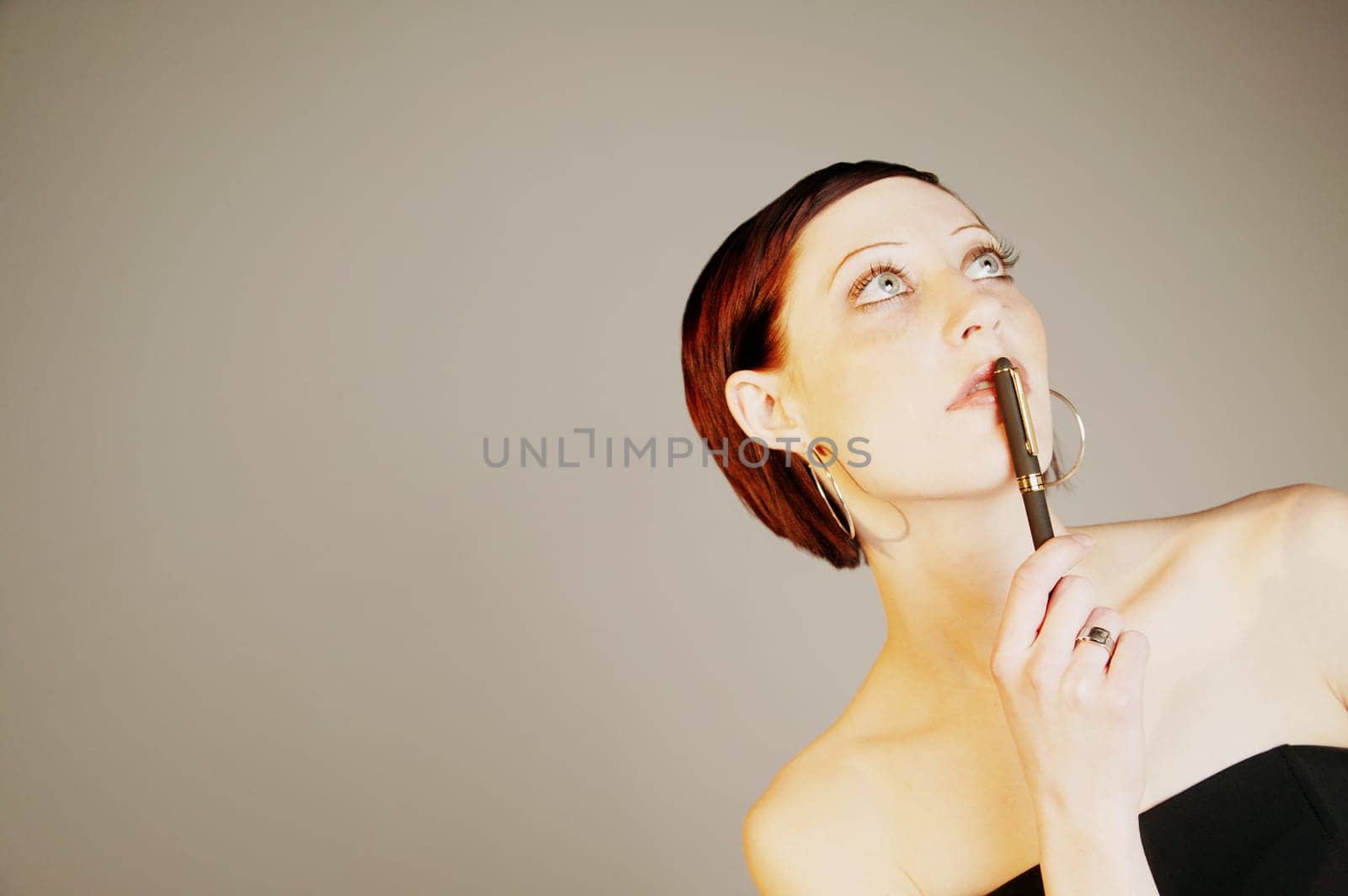 Woman holding pen to mouth