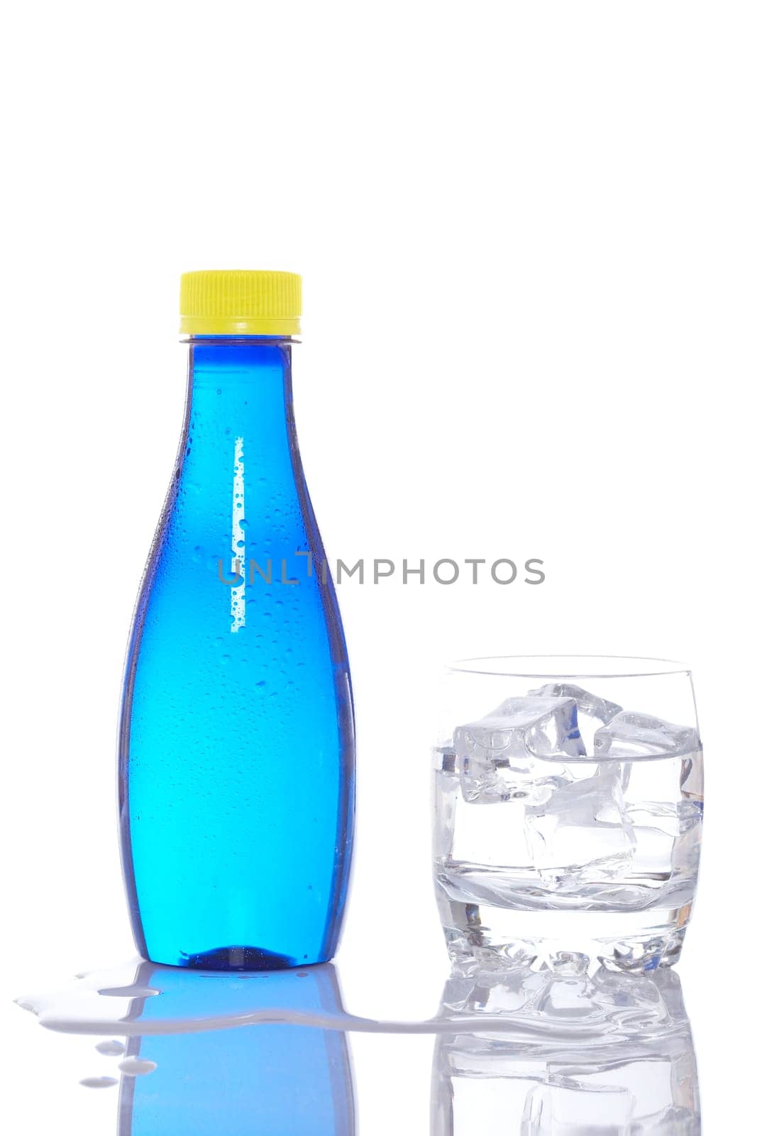 Bottle and glass of mineral water with droplets