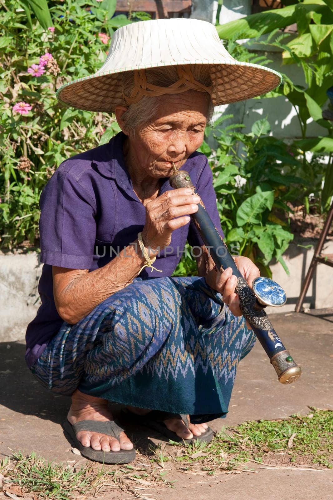 old asian woman with opium pipe