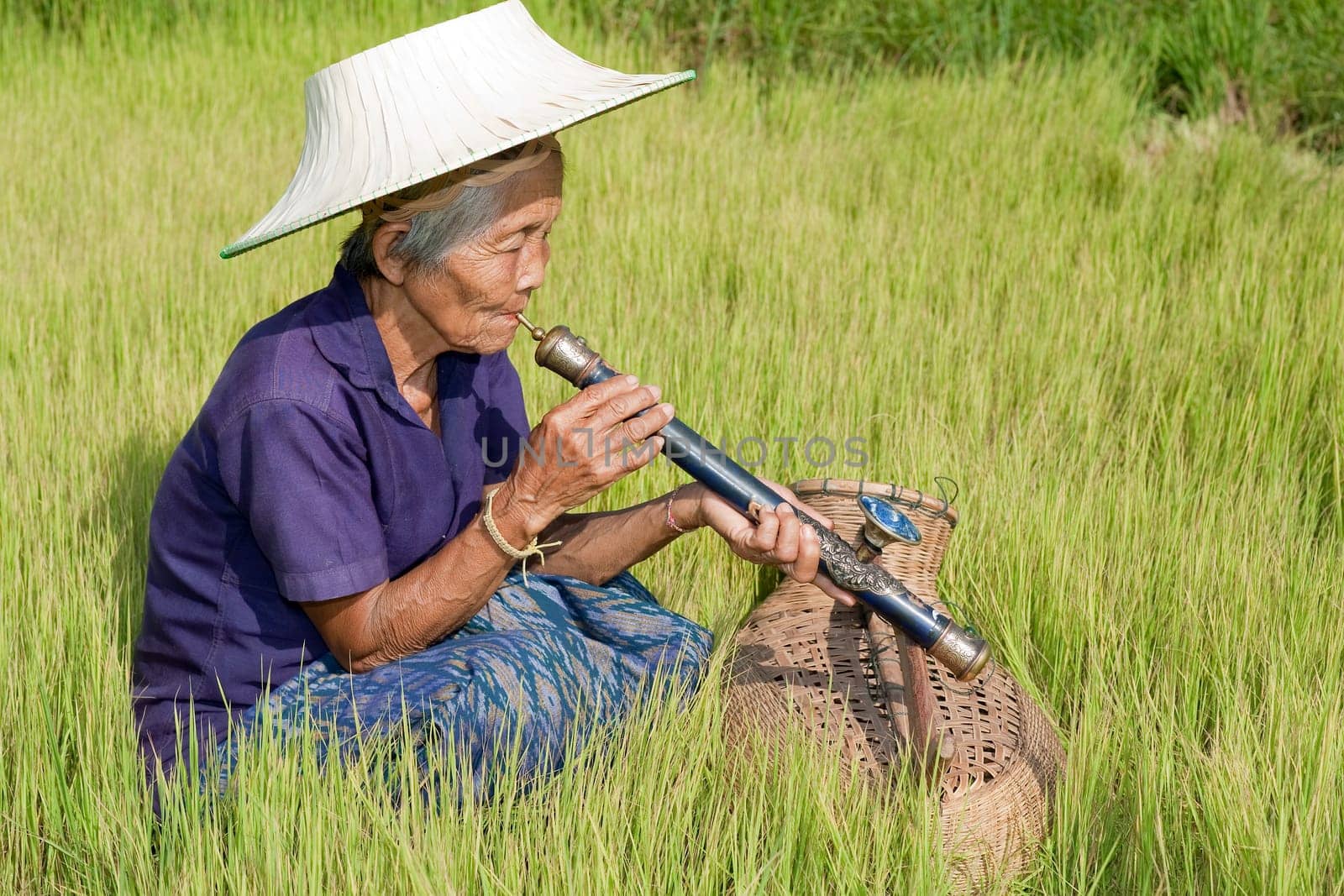 old asian woman with opium pipe