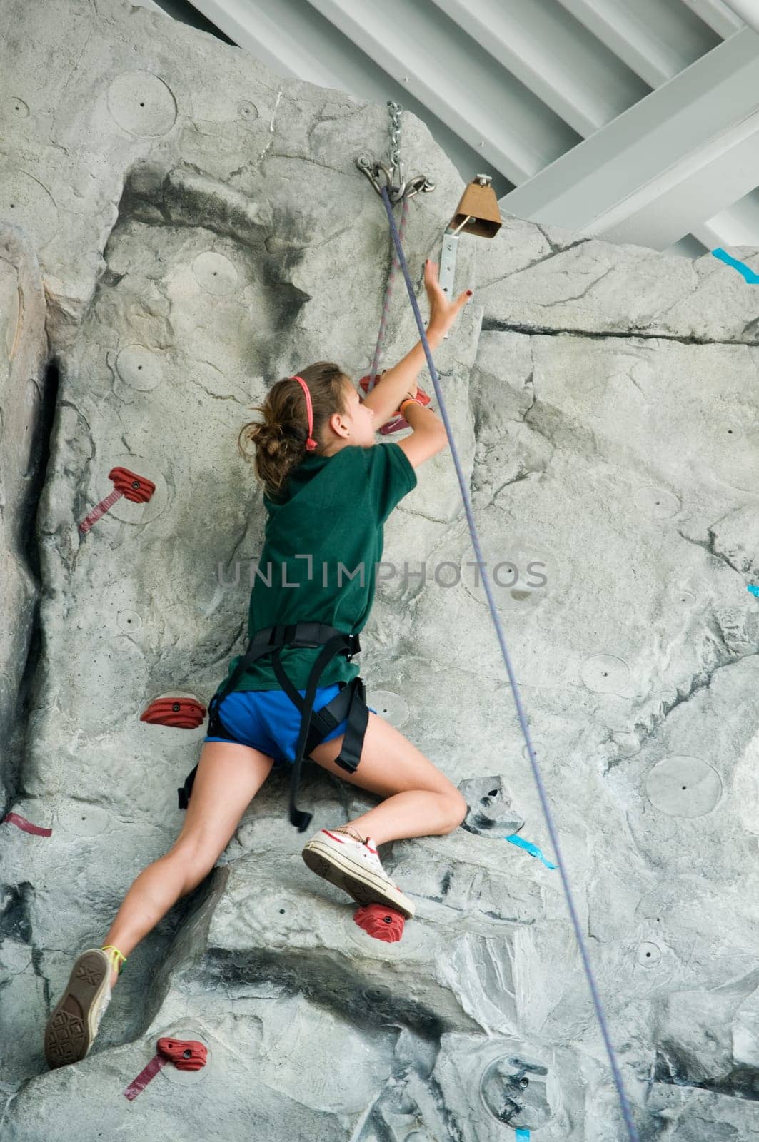 young teen girl rock climbing