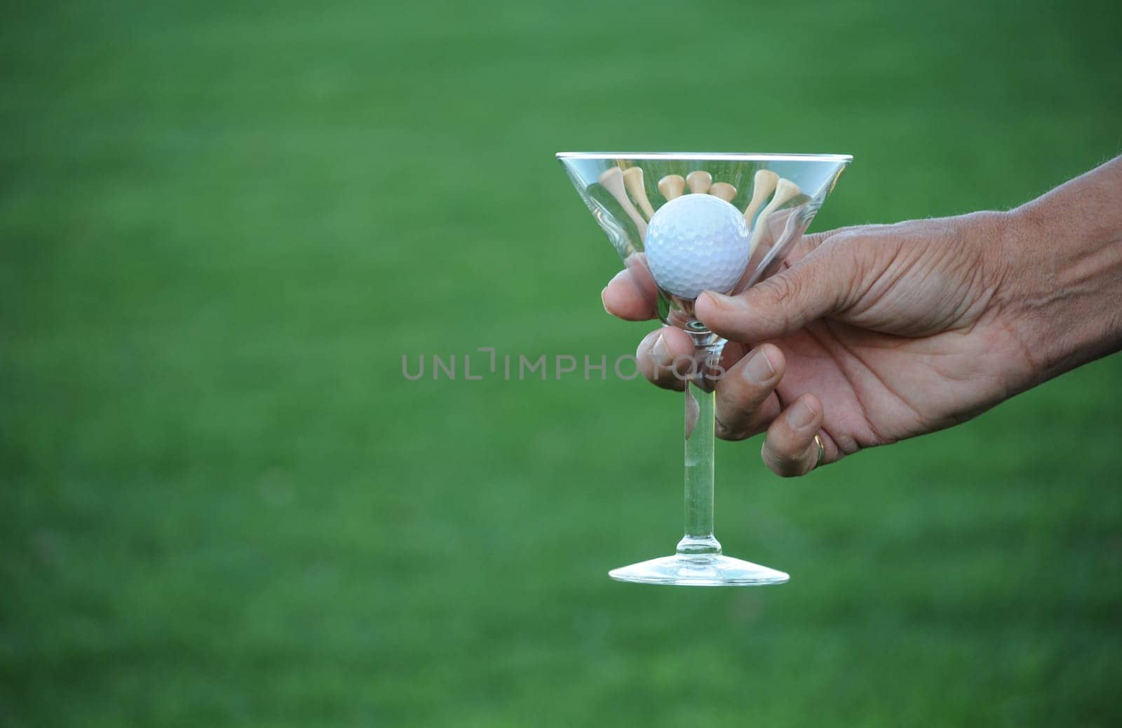 golf ball and tees in martini glass