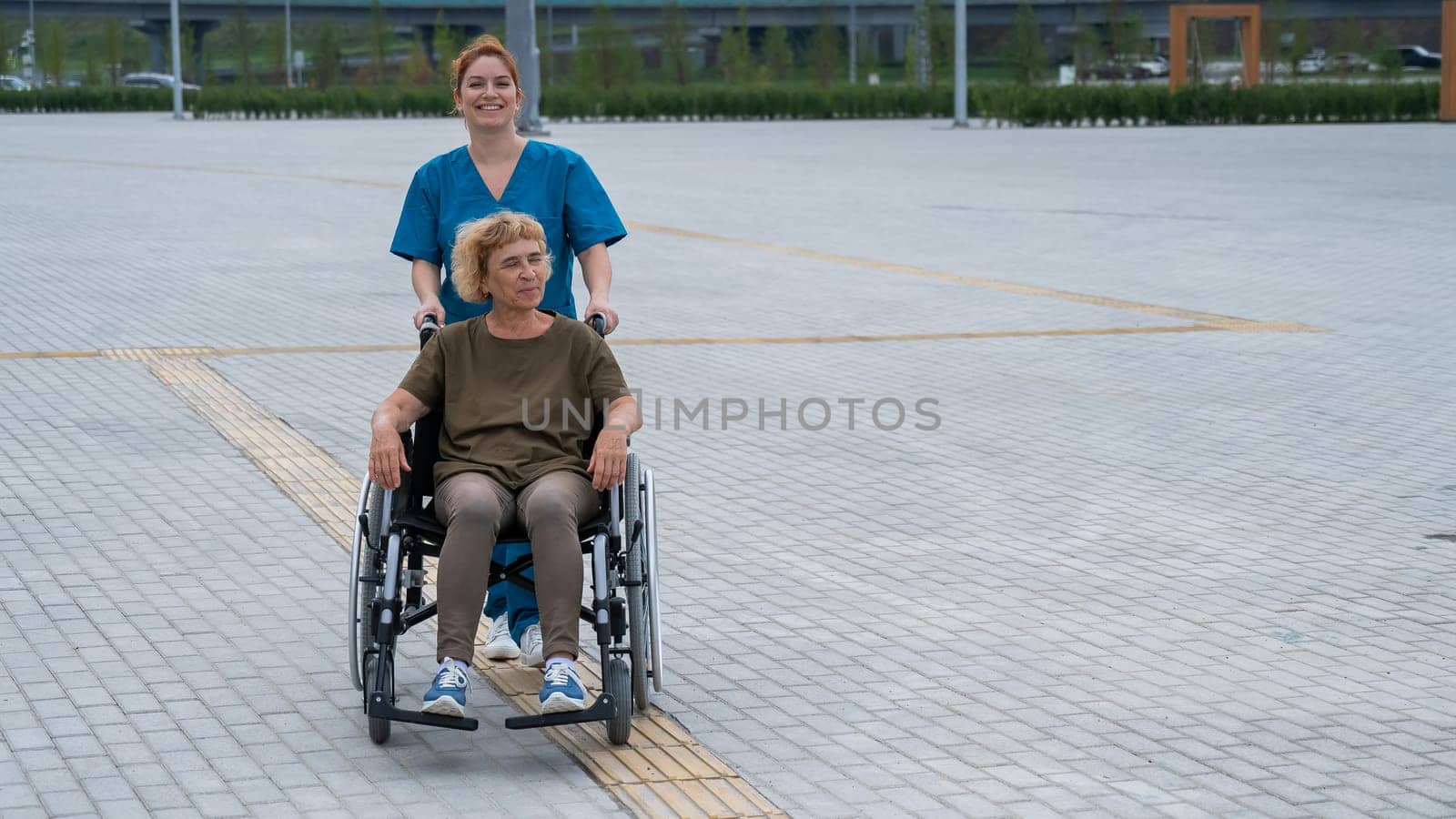 Caucasian nurse pushing elderly woman in wheelchair outdoors