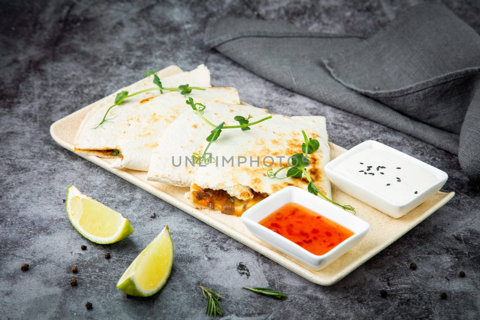 crispy flatbreads stuffed with meat, herbs, lime and two sauces, side view by tewolf