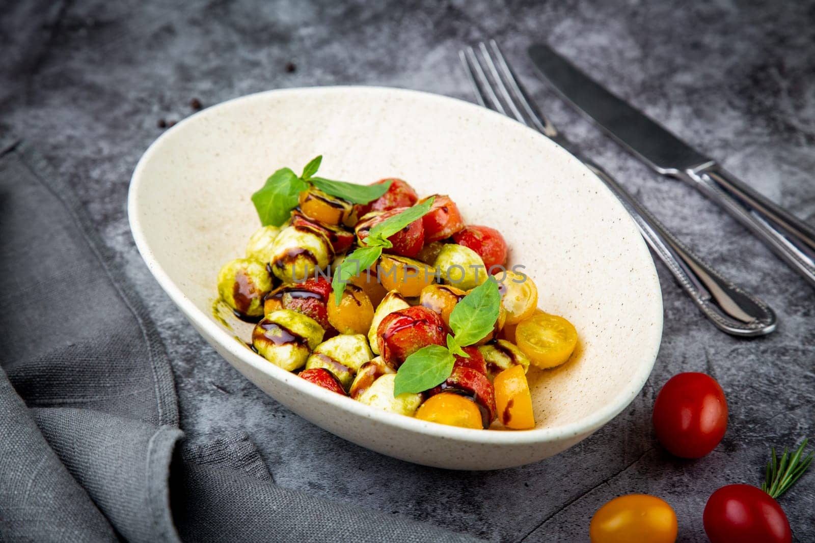 salad of yellow and red cherry tomatoes of different varieties with herbs side view by tewolf