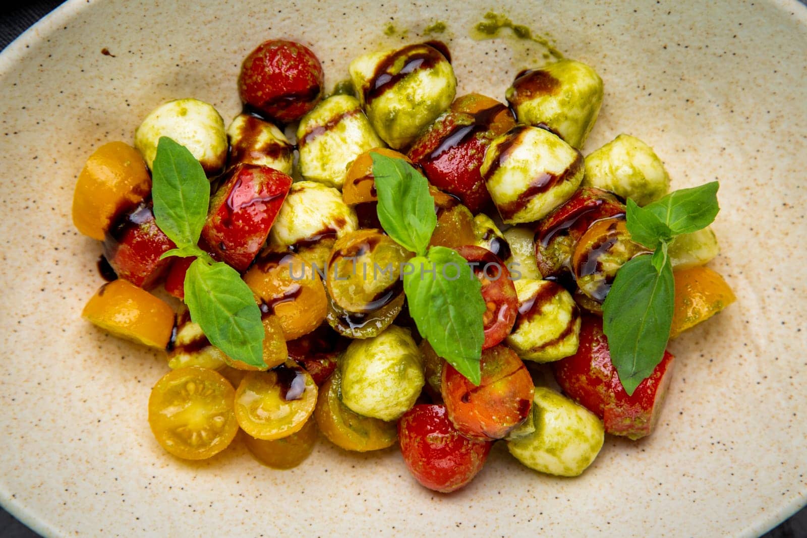 salad of yellow and red cherry tomatoes of different varieties with herbs top view by tewolf