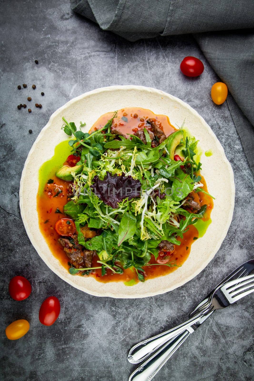 salad of arugula, lettuce leaves, cherry tomatoes and avocado