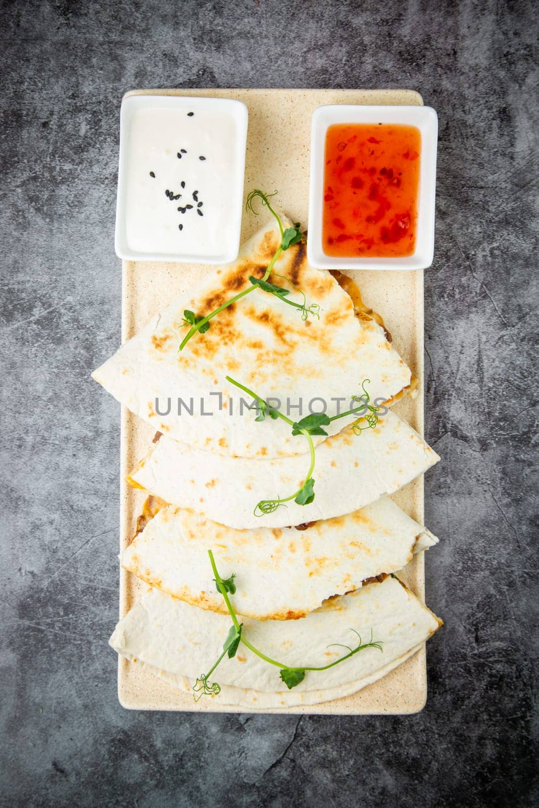 crispy flatbreads stuffed with meat, herbs, lime and two sauces, top view by tewolf