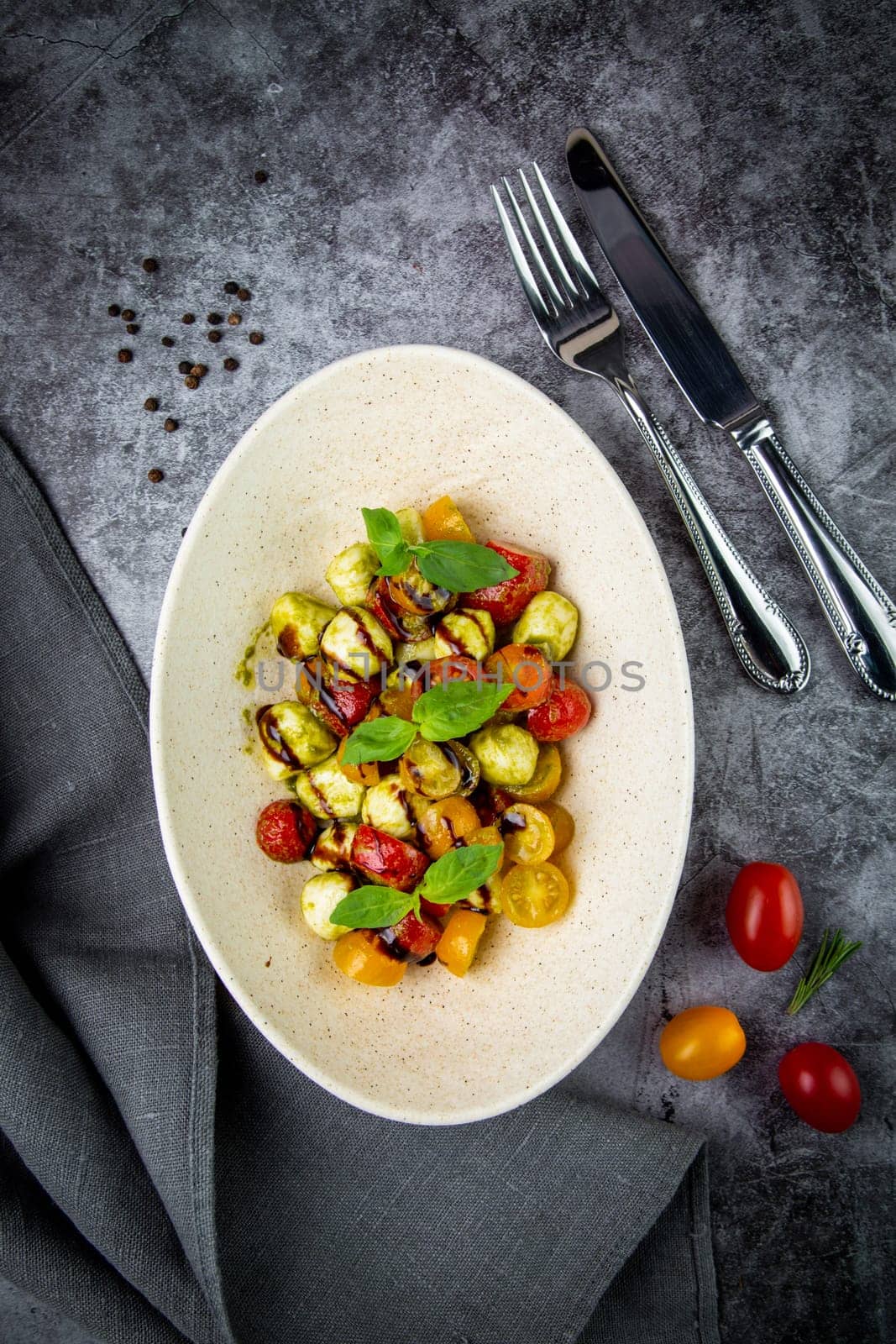 salad of yellow and red cherry tomatoes of different varieties with herbs top view by tewolf