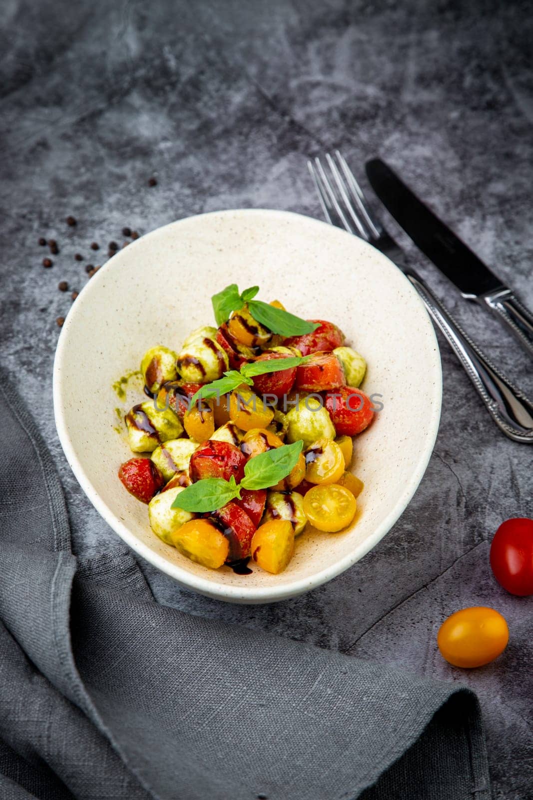 salad of yellow and red cherry tomatoes of different varieties with herbs top view by tewolf