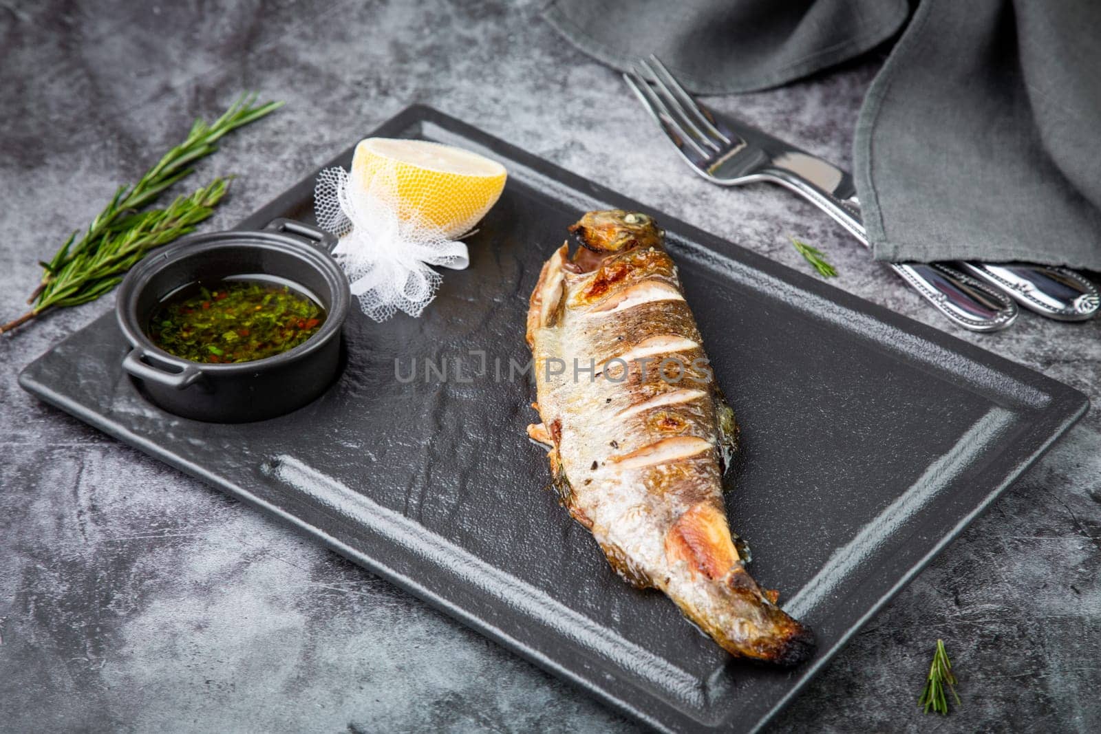 baked fish with broth and lemon, side view by tewolf