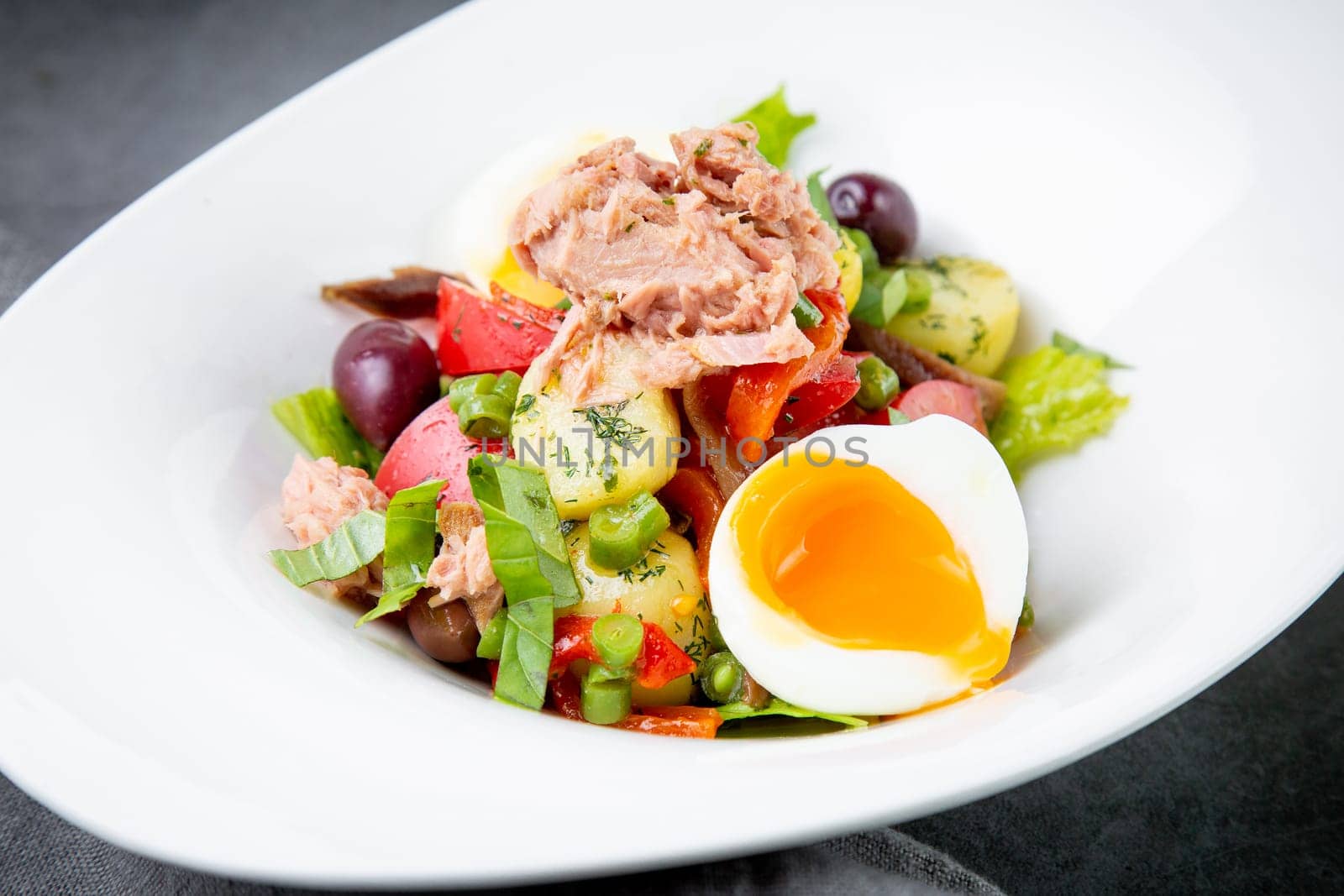 salad with soft-boiled egg, tuna, green onions, boiled potatoes, side view by tewolf