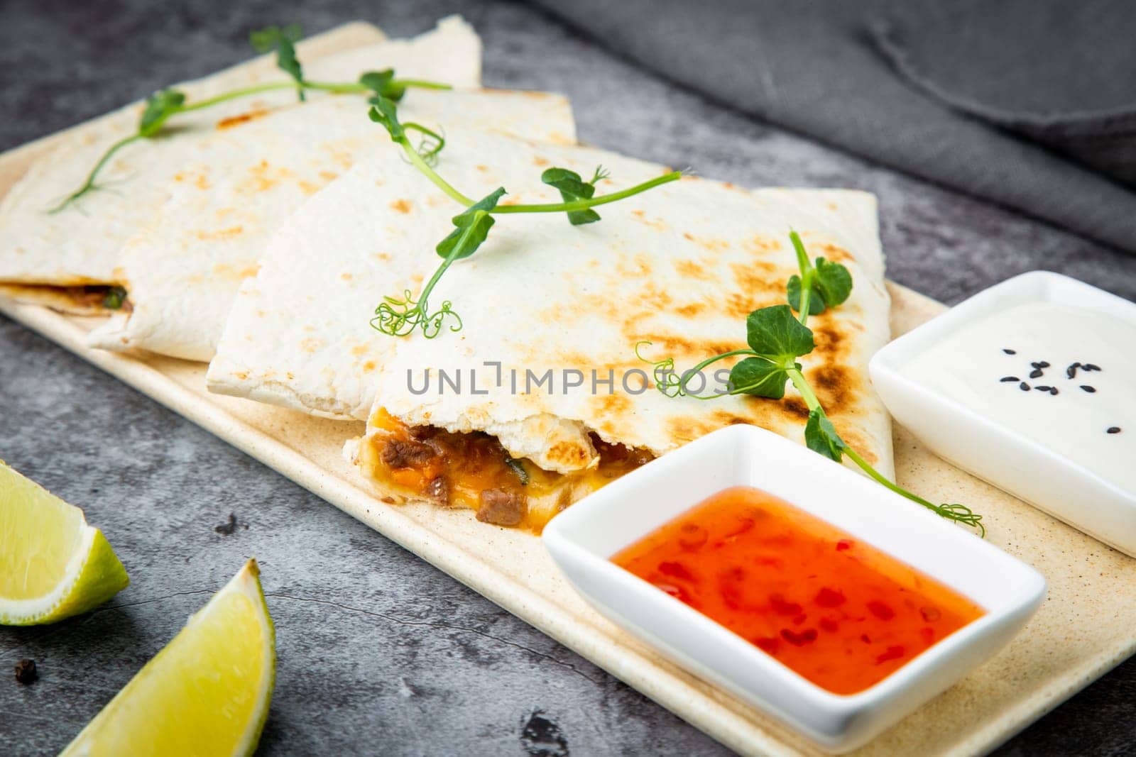 crispy flatbreads stuffed with meat, herbs, lime and two sauces, side view by tewolf