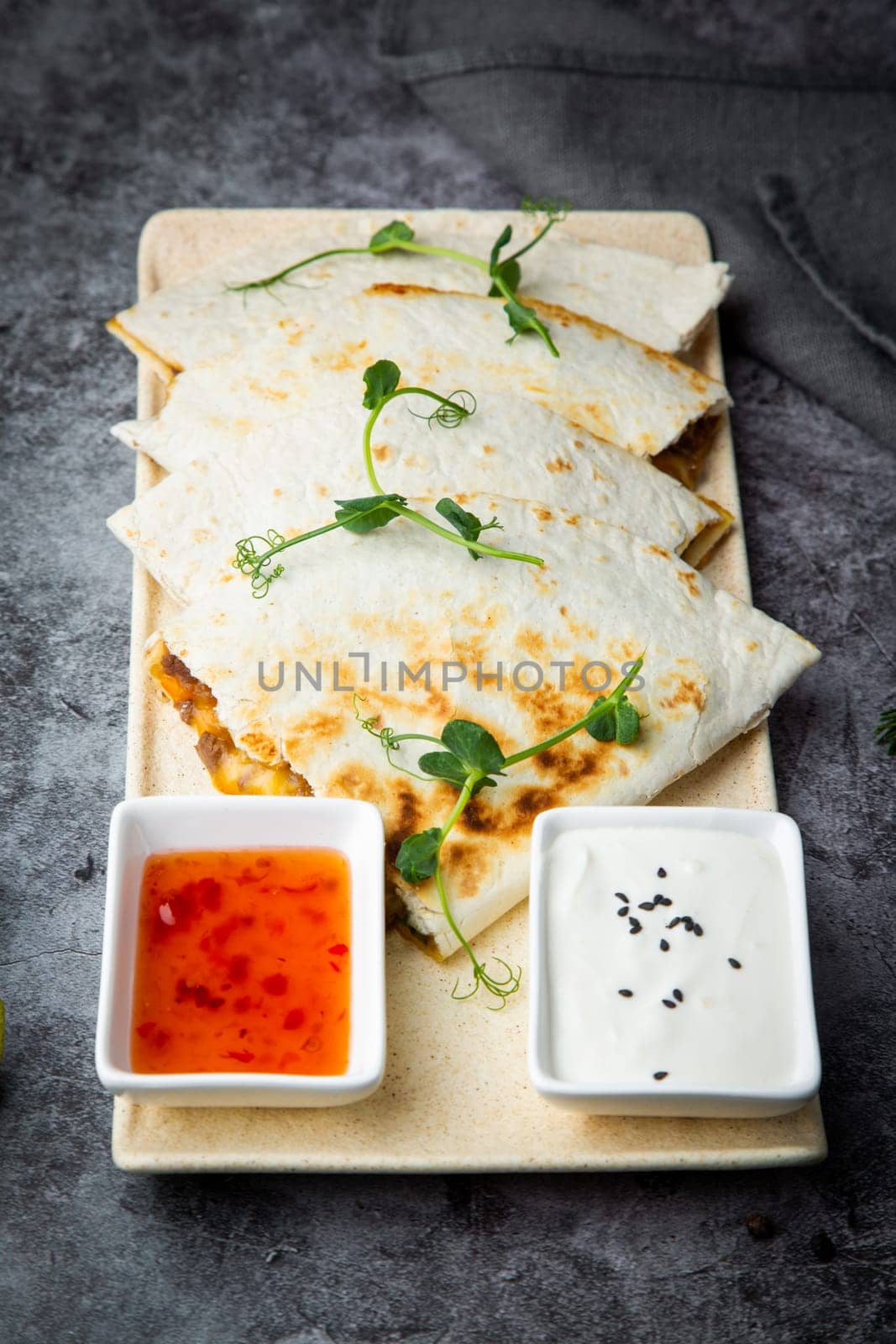 crispy flatbreads stuffed with meat, herbs, lime and two sauces, side view by tewolf