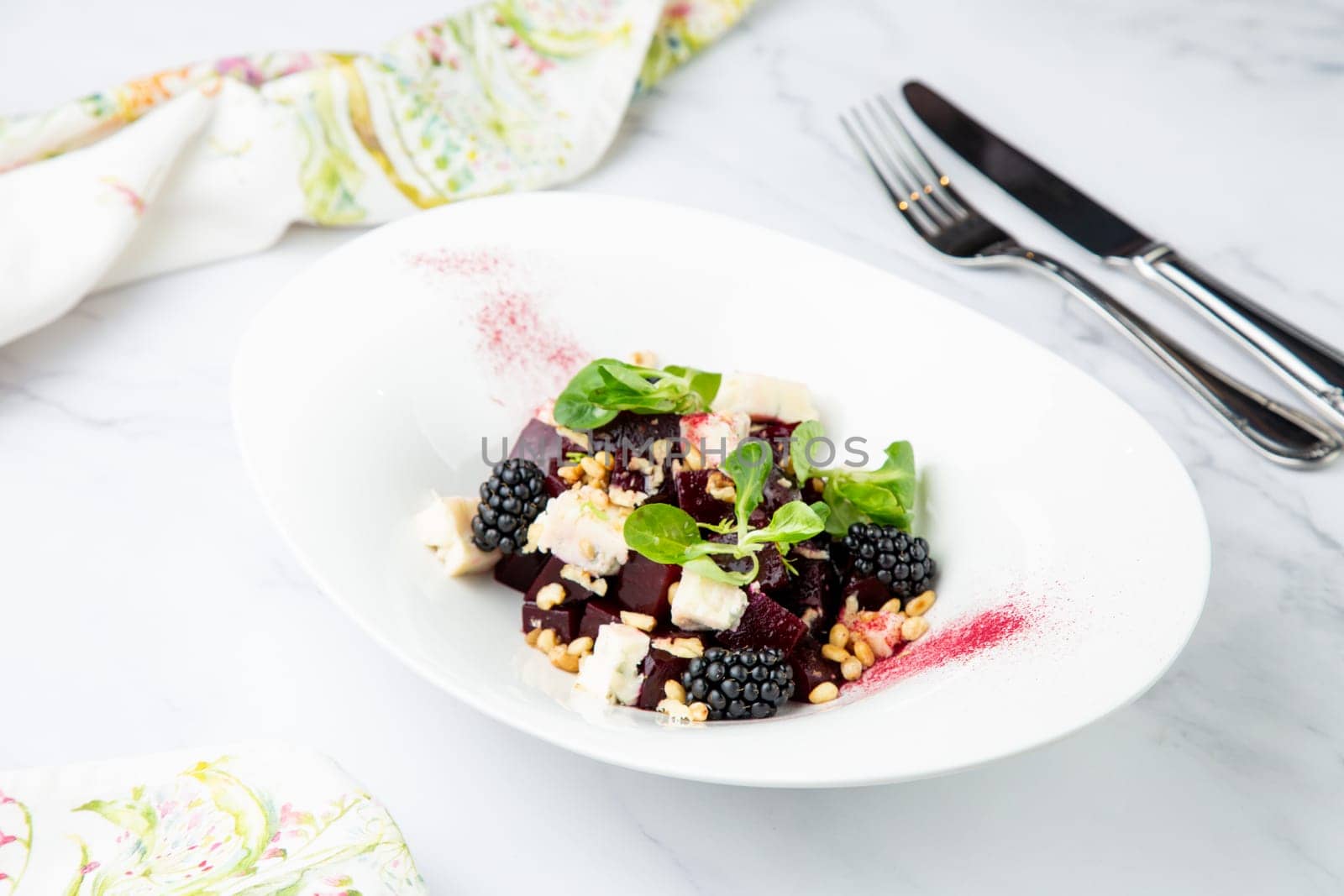 salad of blackberries, beets, seeds and cheese, side view on a white plate by tewolf