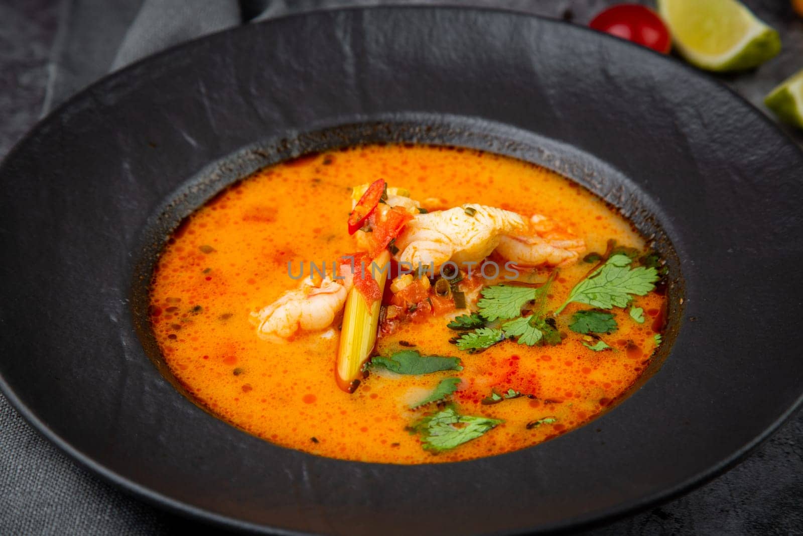 tom yam soup with chicken, lime, cherry tomatoes and parsley