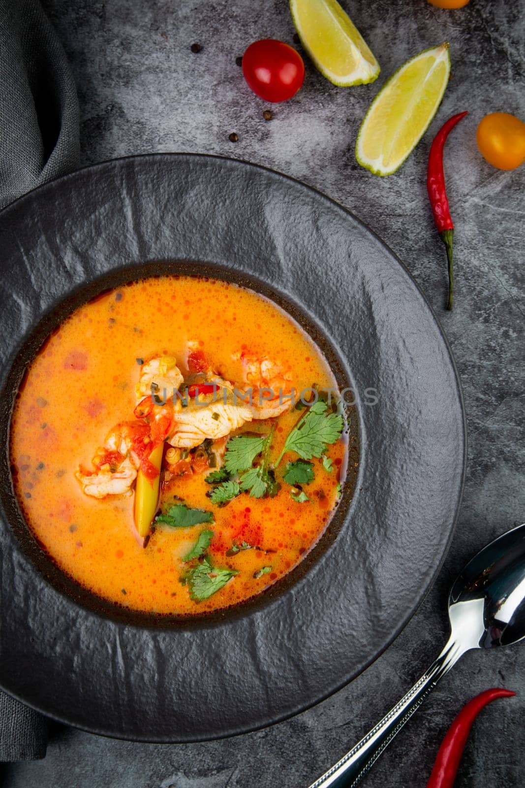 tom yam soup with chicken, lime, cherry tomatoes and parsley