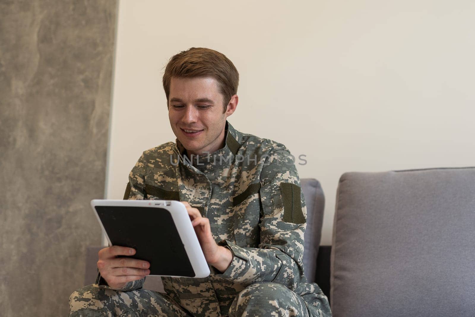 Military man waving. military man waving while having video chat with family on tablet.