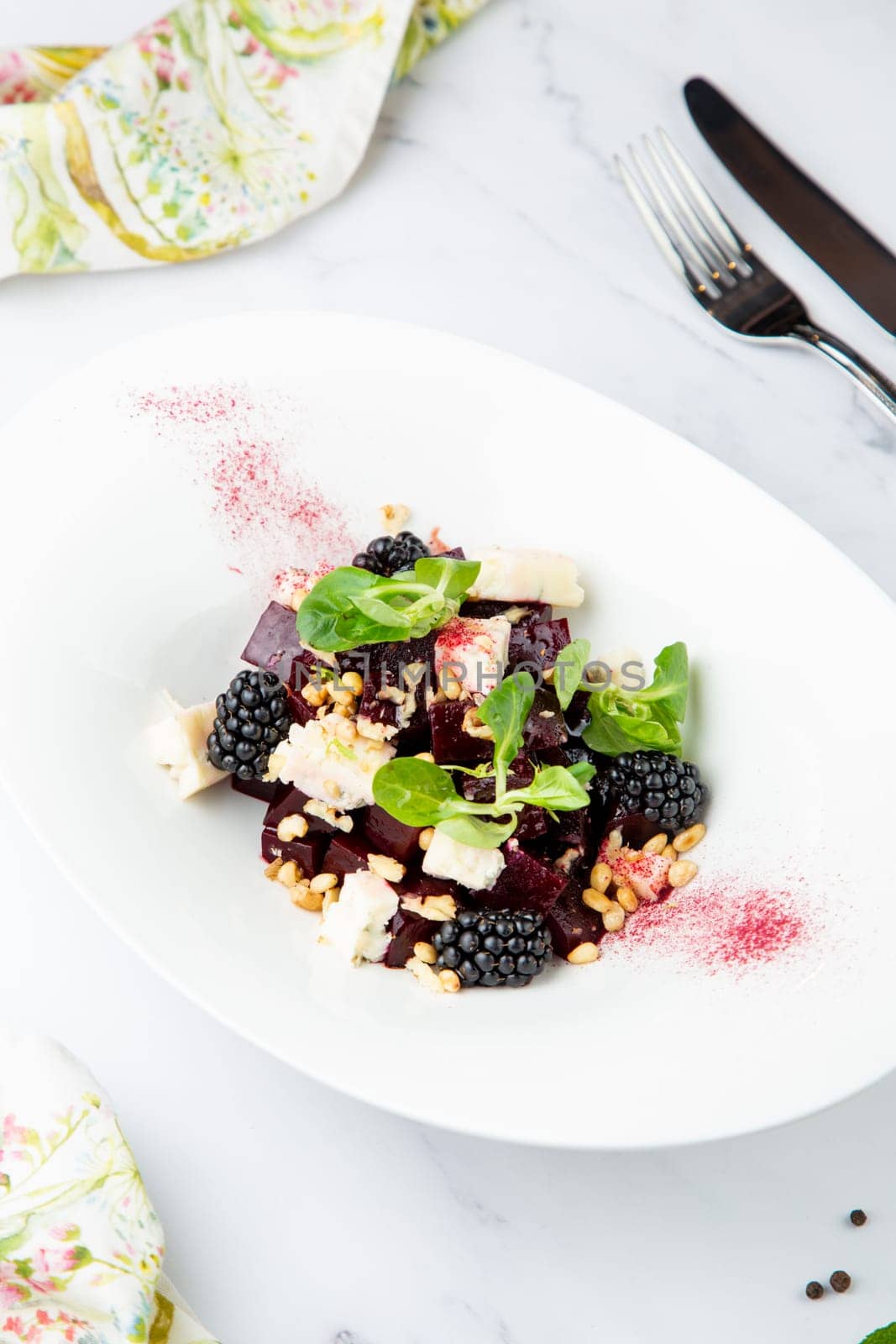 salad of blackberries, beets, seeds and cheese, side view on a white plate by tewolf