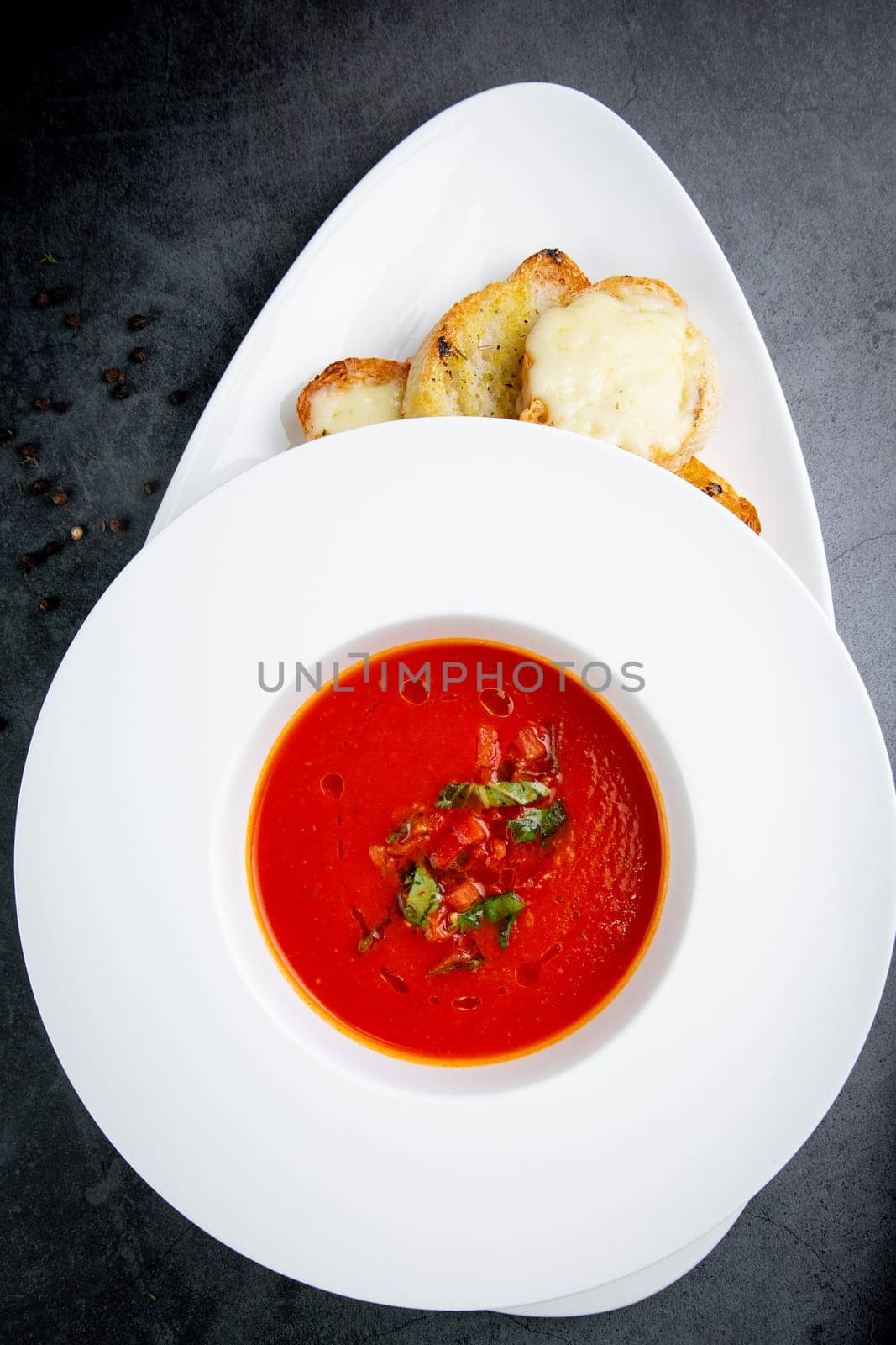 red tomato cream soup with herbs and toasted bread