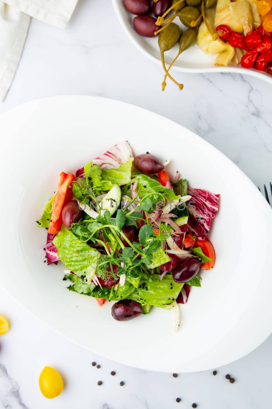 salad of greens, lettuce leaves, cucumbers, pink onions, top view by tewolf