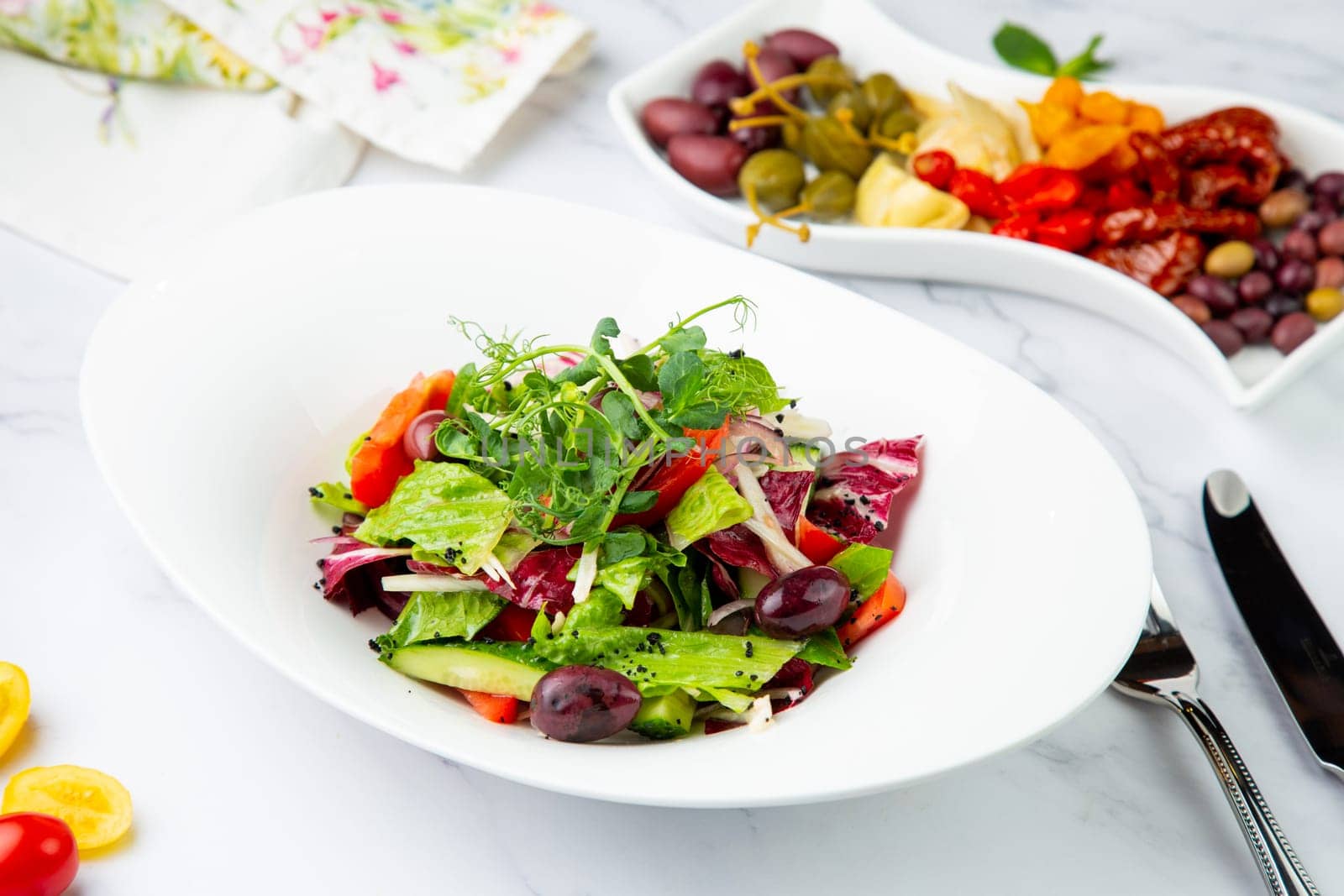 salad of greens, lettuce leaves, cucumbers, pink onions, side view by tewolf