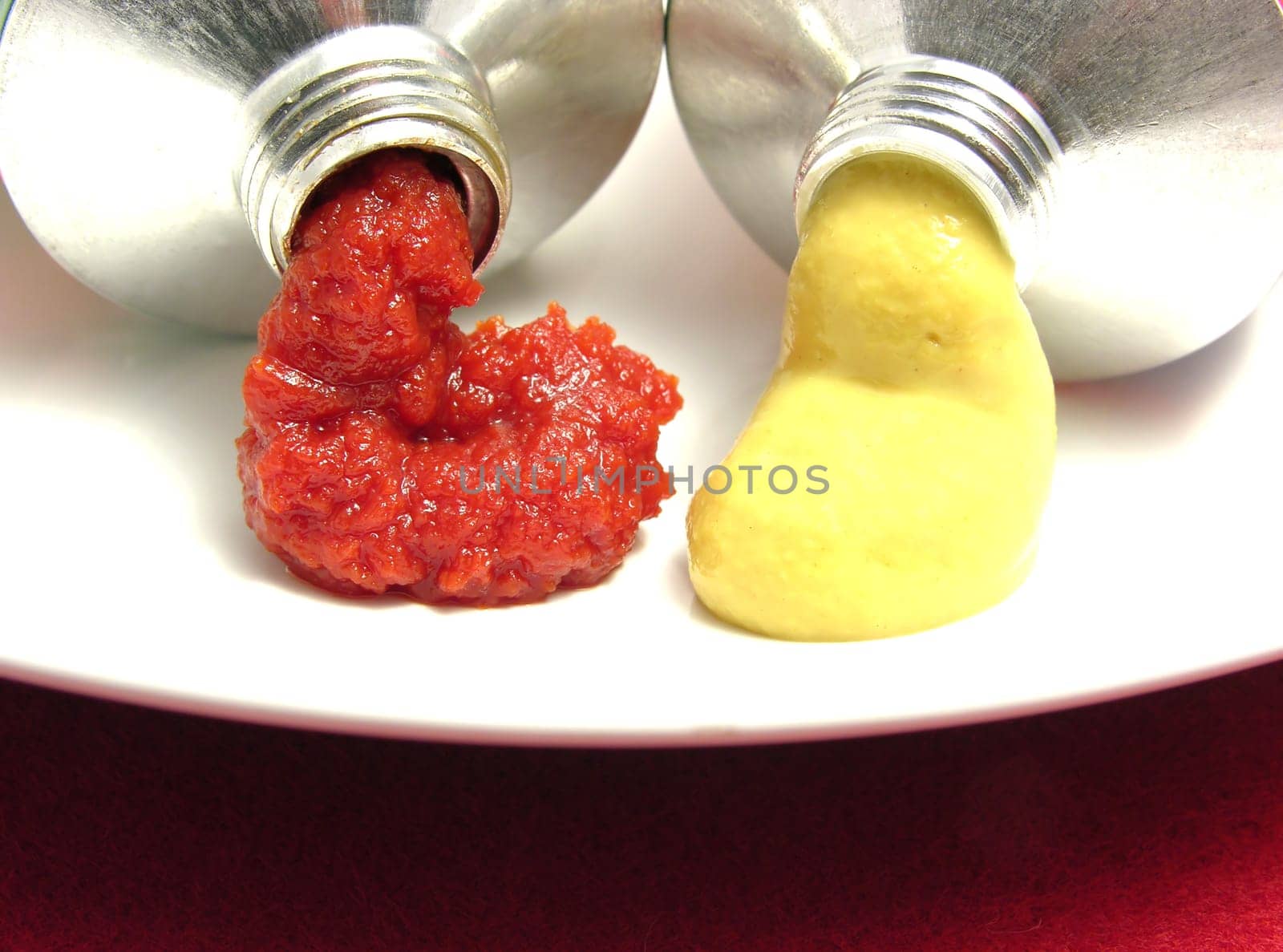Two open tubes with tomato paste and mustard
