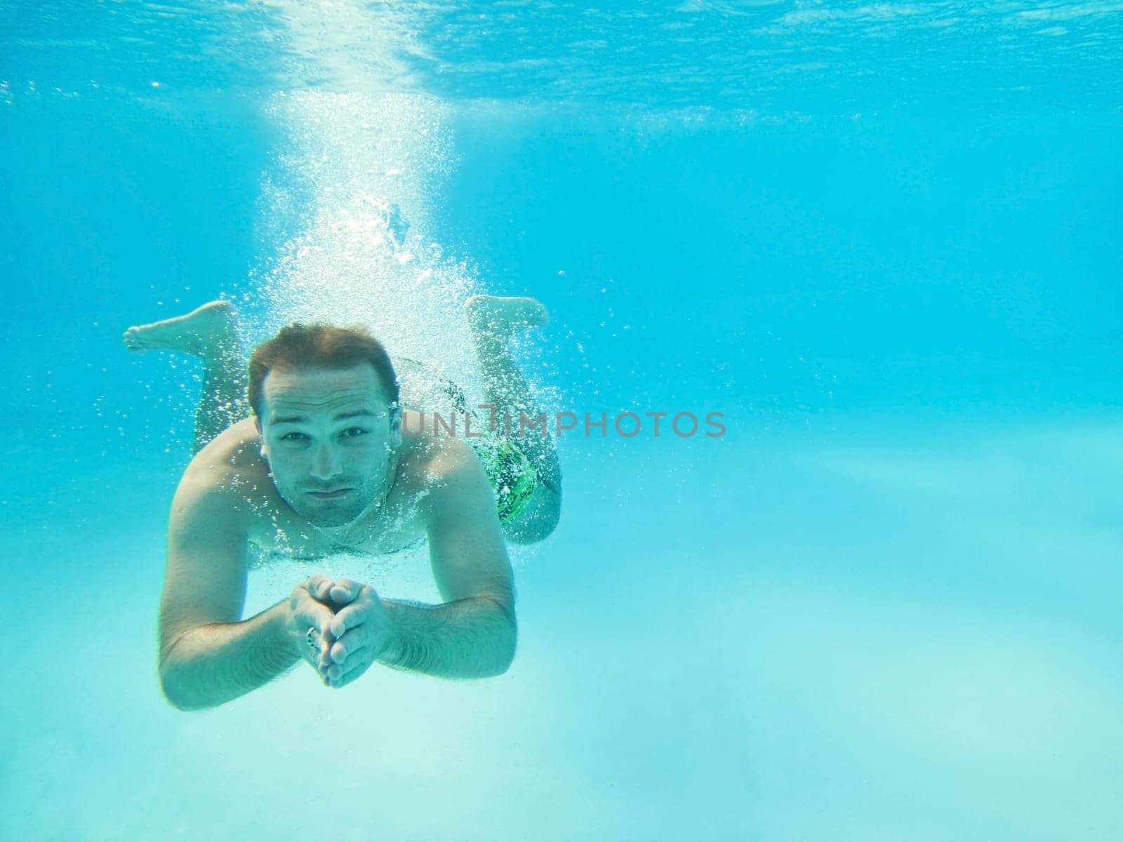 Man swimming under water in pool