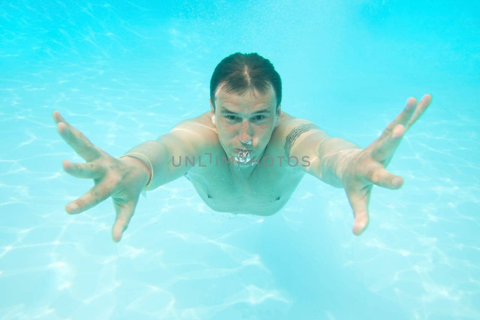 Man swimming under water in pool