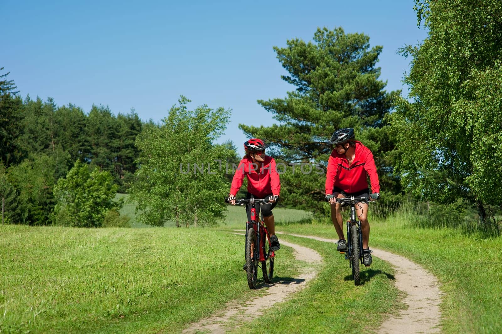 Summer - young man woman couple ride mountain bike in nature