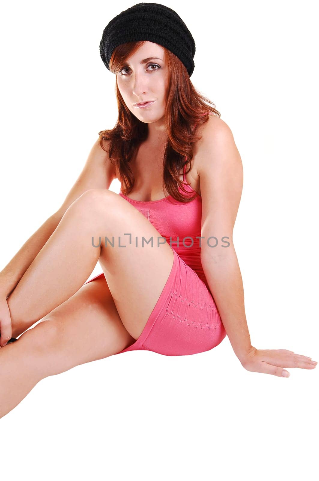 Pretty girl in pink short dress sitting on floor.