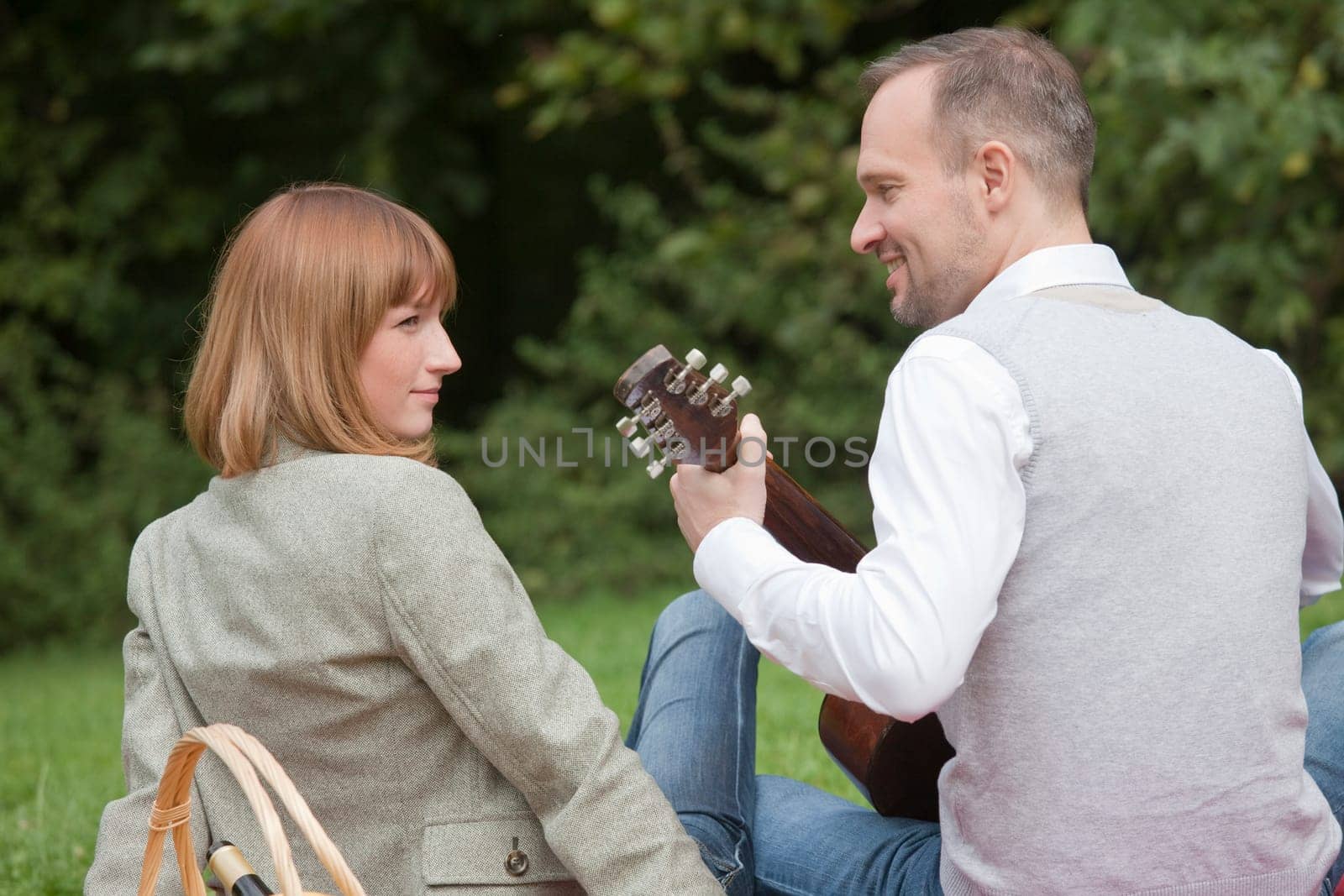 Man playing guitar,woman listening