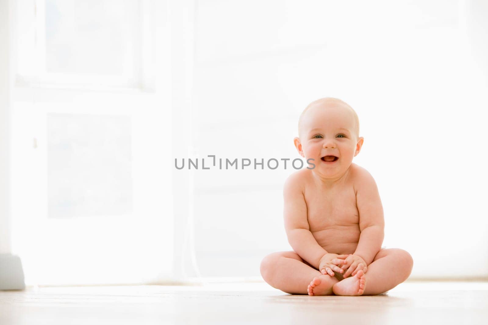 Baby sitting indoors smiling