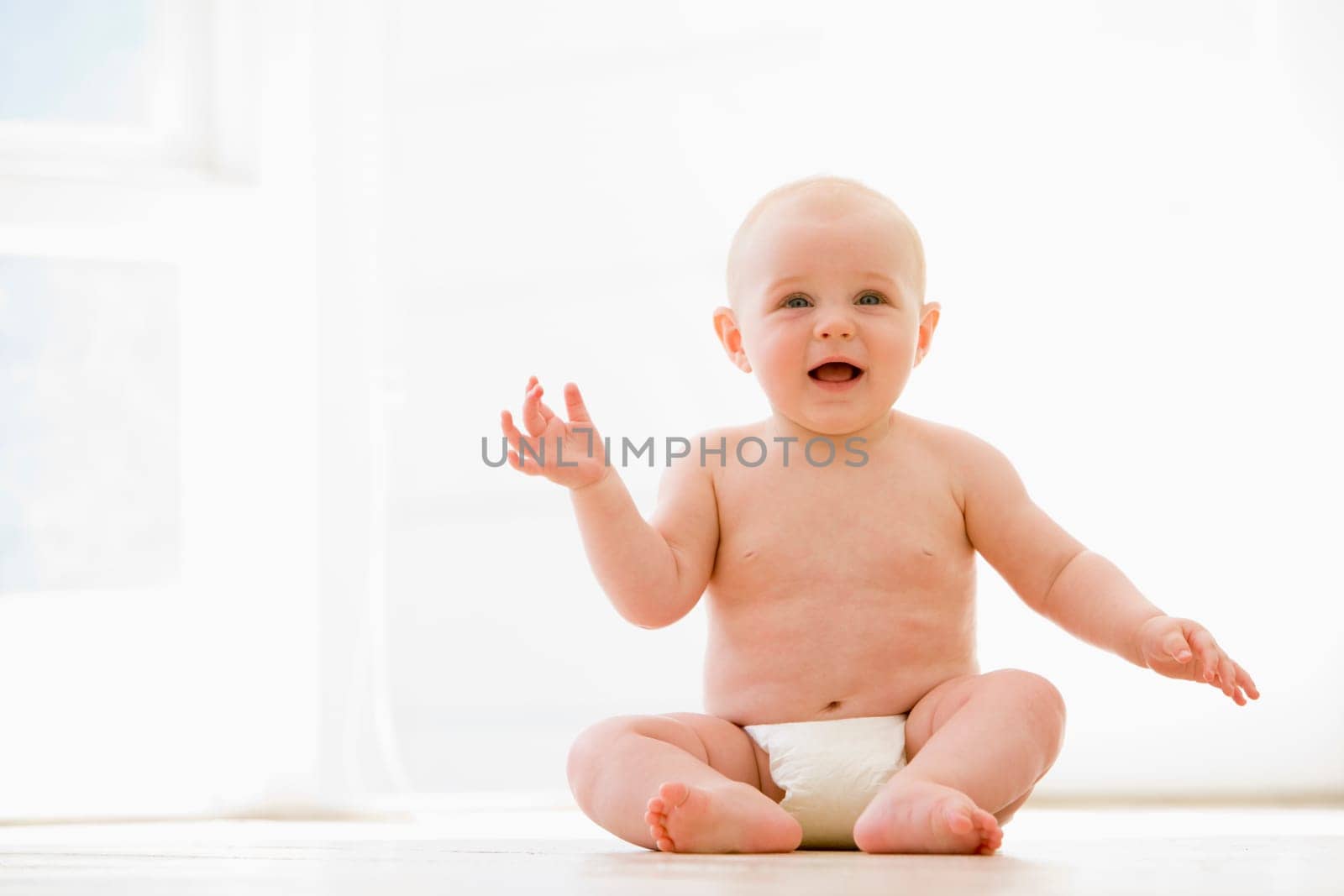 Baby sitting indoors smiling