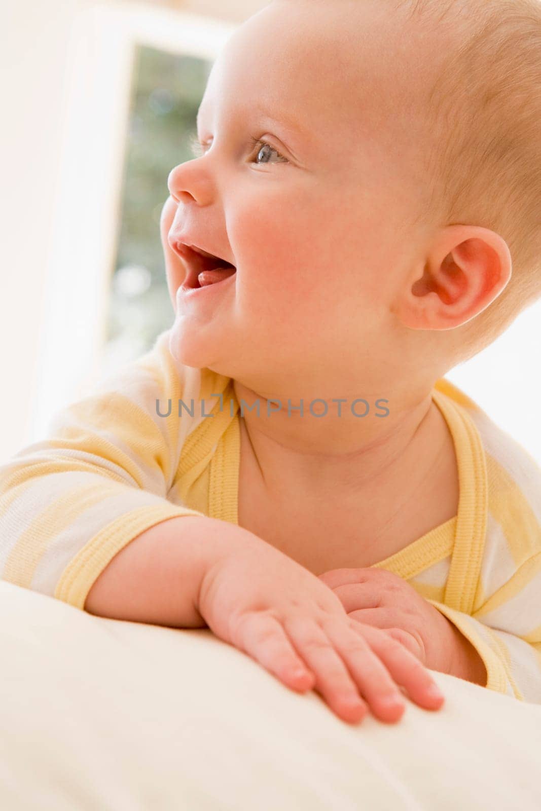 Baby lying indoors smiling